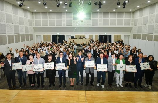 김포시아트빌리지 아트센터에서 열린 2023 가정의 달 기념식. 객석에 앉은 참석자들과 함께 기념사진 촬영 중인 내외빈들. 사진 상 왼쪽 여섯 번째가 김병수 김포시장이다.